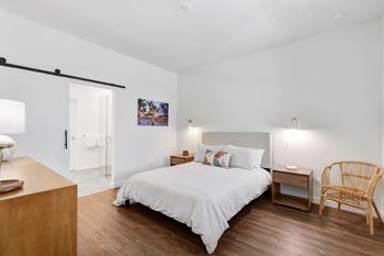 a bedroom with a bed and a dresser and a door to a bathroom at Odyssey, Fort Myers, FL, 33905